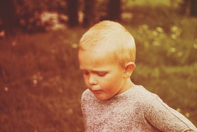 Portrait of cute boy looking away outdoors