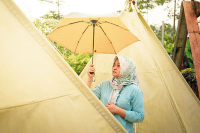 Low angle view of woman with umbrella