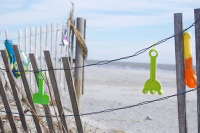 Close-up of toys hanging on clothesline against sky