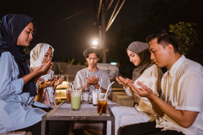 Friends using mobile phone while sitting at restaurant