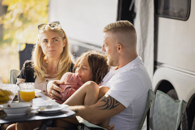 Parents and child sitting at picnic table