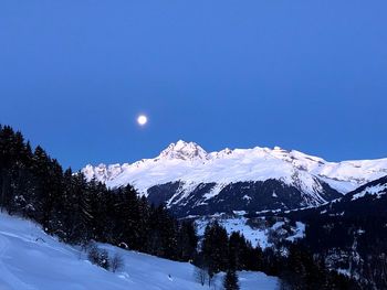 Scenic view of snowcapped mountains against blue sky