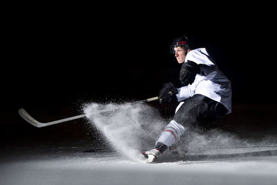 Man playing ice hokey at night