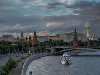 Spasskaya tower by moscva river against cloudy sky