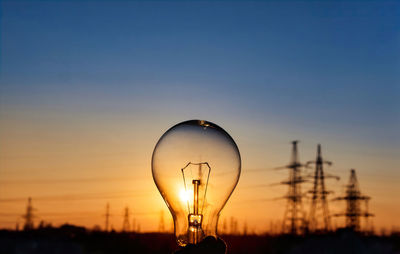 Light bulb with high voltage line on background. electricity and energy savings in the city 