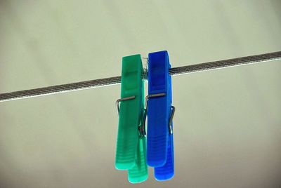 Close-up of clothes hanging on rope against wall