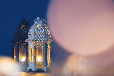 Low angle view of illuminated lamp against blue sky