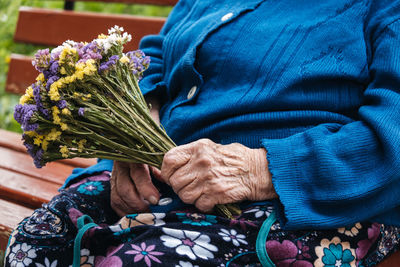 Senior people support. charities for elderly people. close up of senior woman hands with flowers