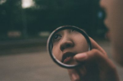 Close-up portrait of young woman looking away outdoors