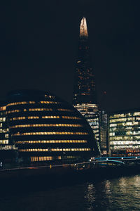 Illuminated buildings against sky at night