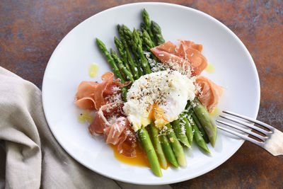 Eggs benedict with parmesan, green asparagus and parma ham