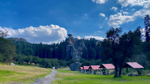 Panoramic shot rock formation and cabins against sky