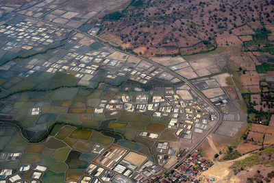 High angle view of field and houses in city