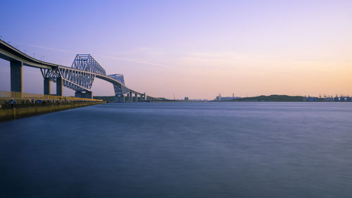 Bridge over river against sky during sunset