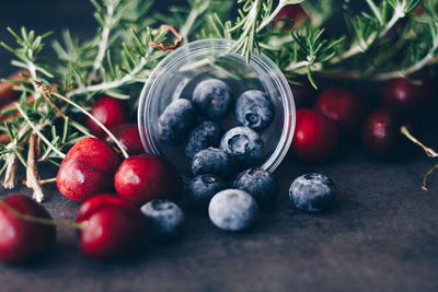 Close-up of fruits with rosemary on table