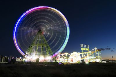 Illuminated ferris wheel at night