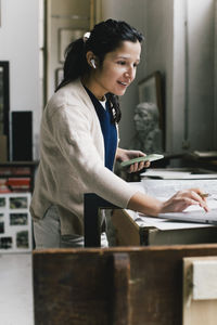 Smiling businesswoman using laptop while working at home office