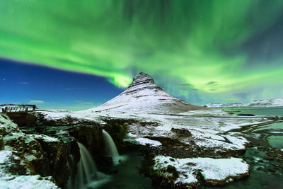 Scenic view of snowcapped mountain against sky at night