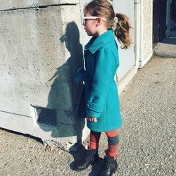 Full length of girl standing against wall