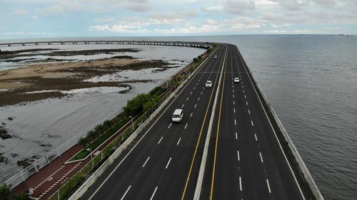 High angle view of highway by sea against sky