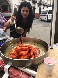 Woman holding food on barbecue grill