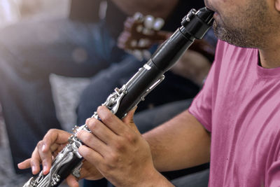 Midsection of man playing guitar