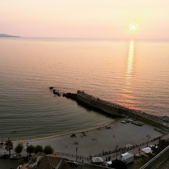 sunset, sea, water, horizon over water, transportation, scenics, high angle view, tranquil scene, tranquility, orange color, beauty in nature, sky, nature, sun, mode of transport, idyllic, dusk, clear sky, reflection, nautical vessel