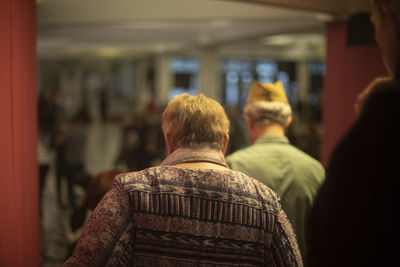 Elderly people leave hall. old people go to meet veterans. people of older age. 