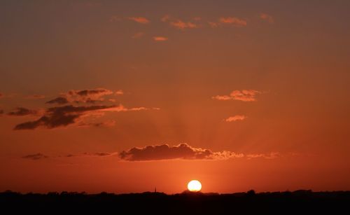 Scenic view of silhouette field against romantic sky at sunset