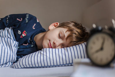 Portrait of boy sleeping on bed at home