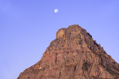 Full moon over sinopah mountain at sunrise in glacier national park