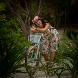 Portrait of young woman sitting on bicycle