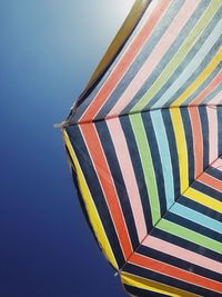 Low angle view of beach umbrella against blue sky