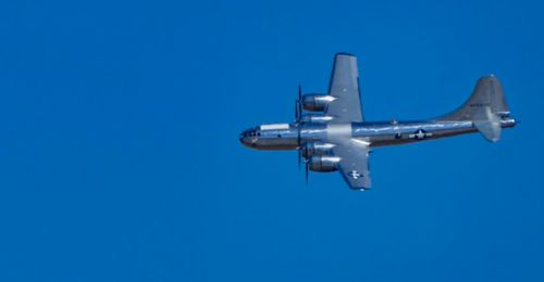 Low angle view of airplane against clear blue sky