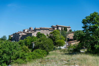 Low angle view of buildings against clear blue sky