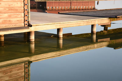 Reflection of bridge in lake against sky