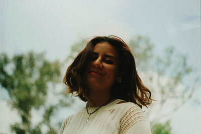 Portrait of smiling woman against sky