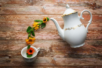 High angle view of teapot and flowers arranged on table