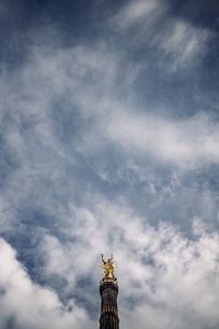 Low angle view of statue of liberty against cloudy sky