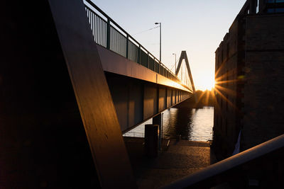 Bridge over footbridge against sky during sunset