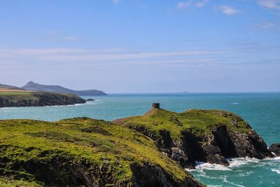 Scenic view of sea and mountains against sky