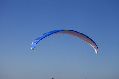 Low angle view of kite flying against blue sky