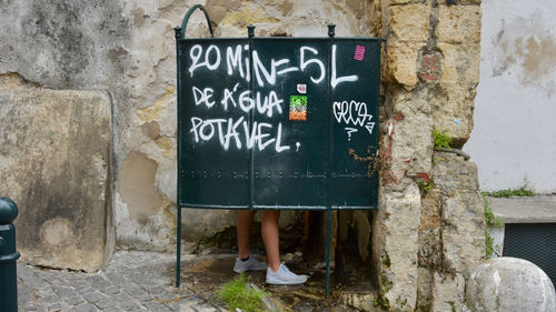 Low section of woman against white wall