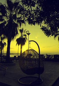 Silhouette of ferris wheel at beach during sunset