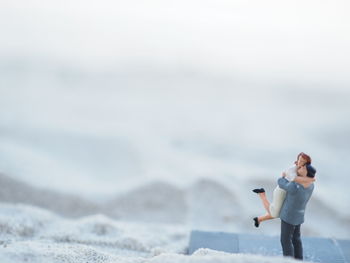 Side view of woman photographing on beach
