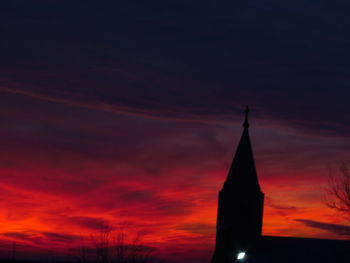 Low angle view of silhouette cross against sky at sunset