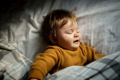 Directly above shot of baby boy sleeping on bed