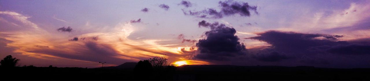 sunset, silhouette, sky, cloud - sky, scenics, beauty in nature, tranquil scene, dramatic sky, cloudy, nature, orange color, cloud, tranquility, weather, idyllic, landscape, atmospheric mood, sunbeam, sun, majestic