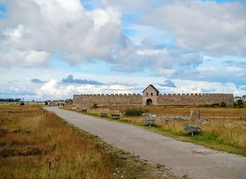 Old castle on field against sky