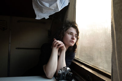 Portrait of young woman sitting on bed at home